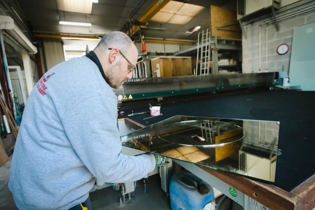 Découpe verre sur mesure d’un miroir en forme circulaire sur la table de coupe de l’atelier MSO