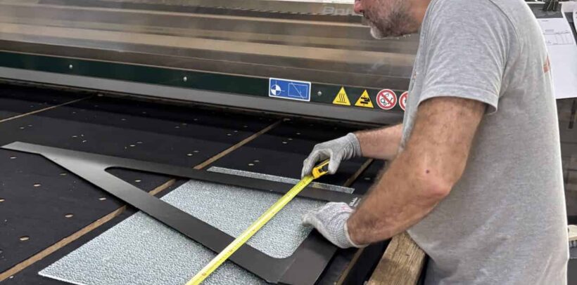 Découpe verre sur mesure : un miroitier MSO contrôle les cotes d’un gabarit dans l’atelier de Lormont